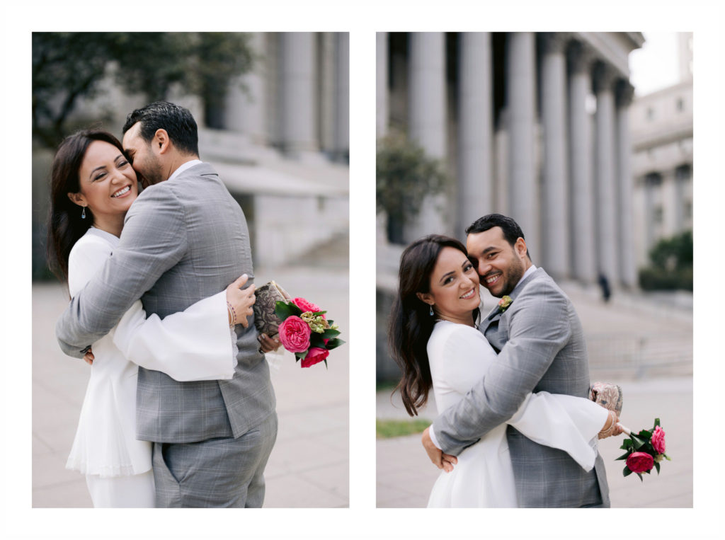a newly married man and his wife hug each other playfully on in front of New York City Hall after eloping