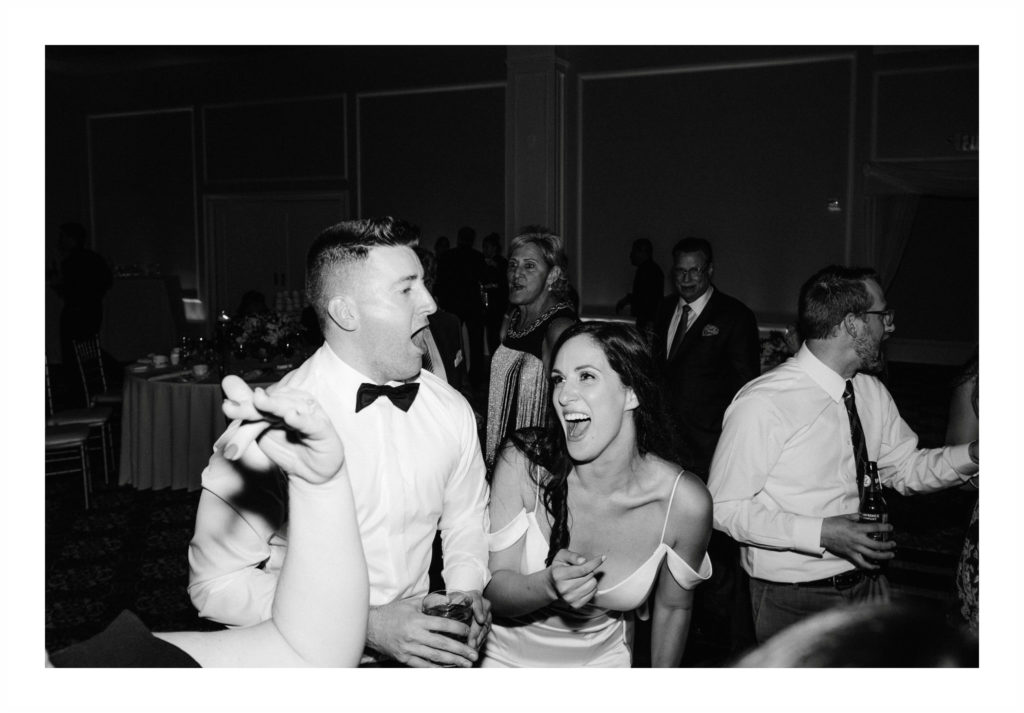 The bride and groom laughing and dancing with their friends and family during an elegant wedding at Le Chateau in South Salem NY.