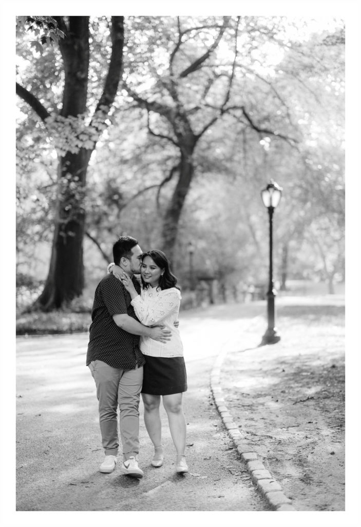 Man kisses his fiancee as they walk through Central Park