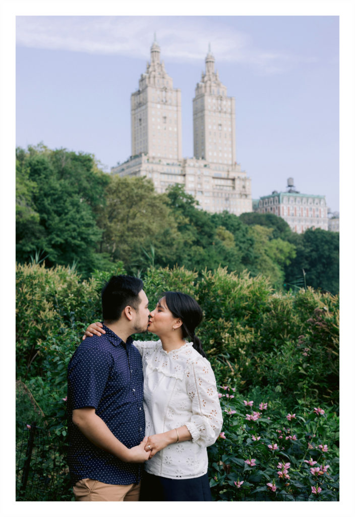 Engaged couple poses while kissing in a park in new York City Jenny Fu Photography
