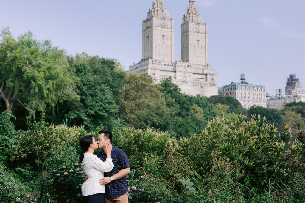 Man and woman kiss during engagement photos in park in New York City