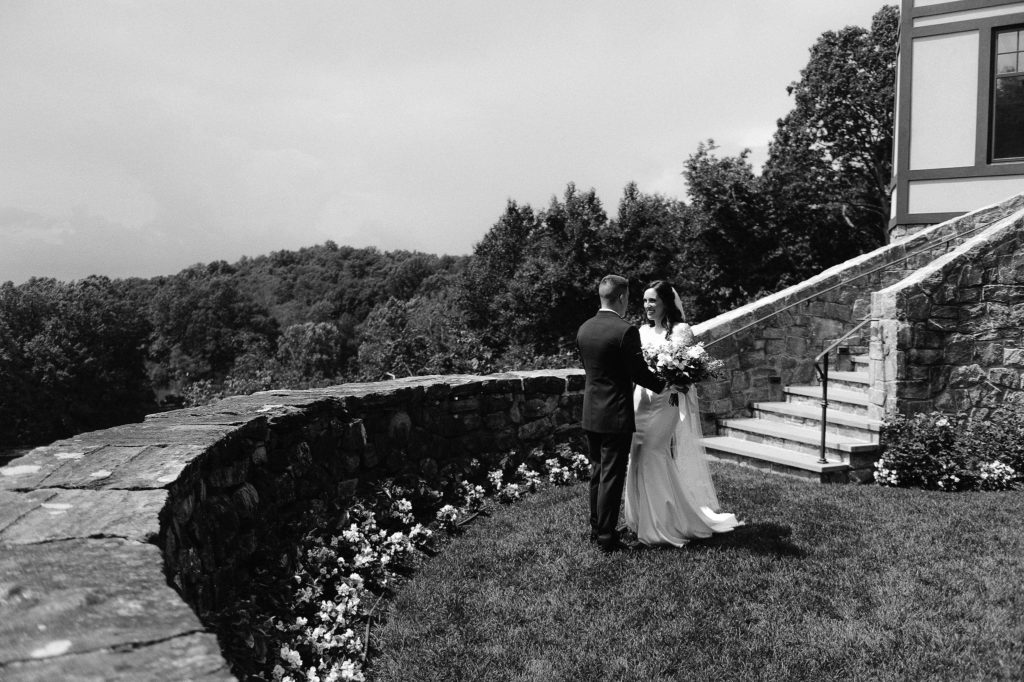 A bride and groom have a First Look on the grounds of the elegant Le Chateau wedding venue in South Salem New York