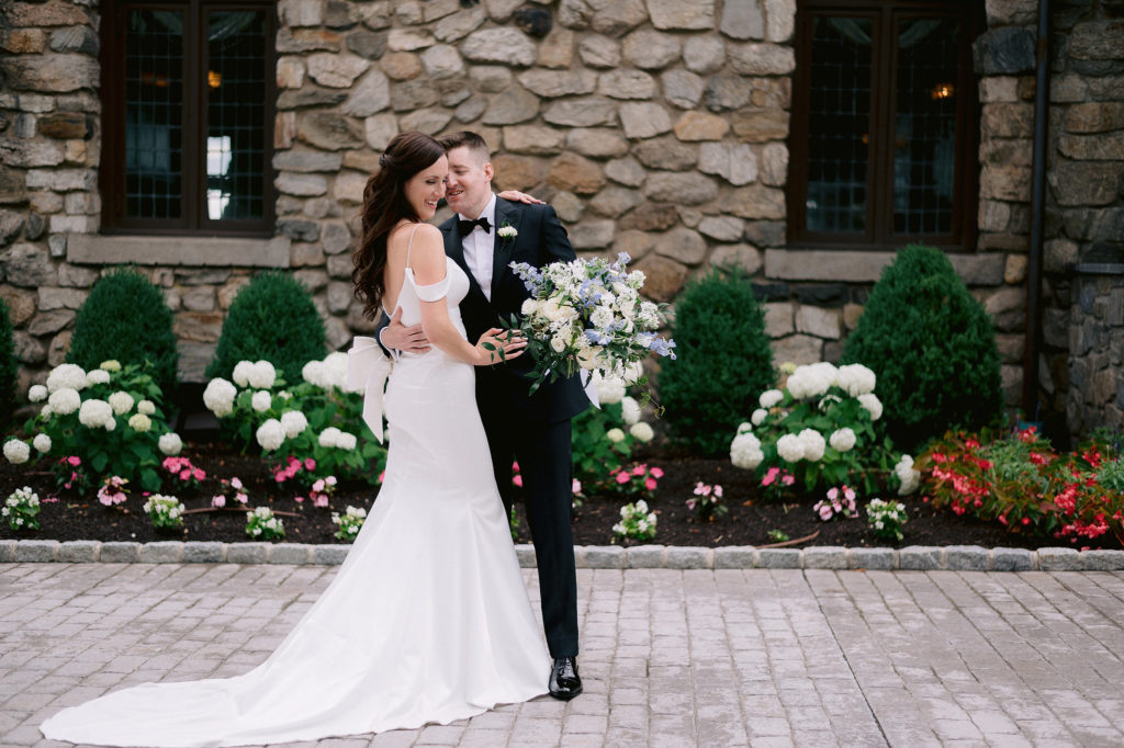 Newlyweds pose for an elegant portrait in front of Le Chateau wedding venue in New York. Images by Jenny Fu New York Wedding Photographer