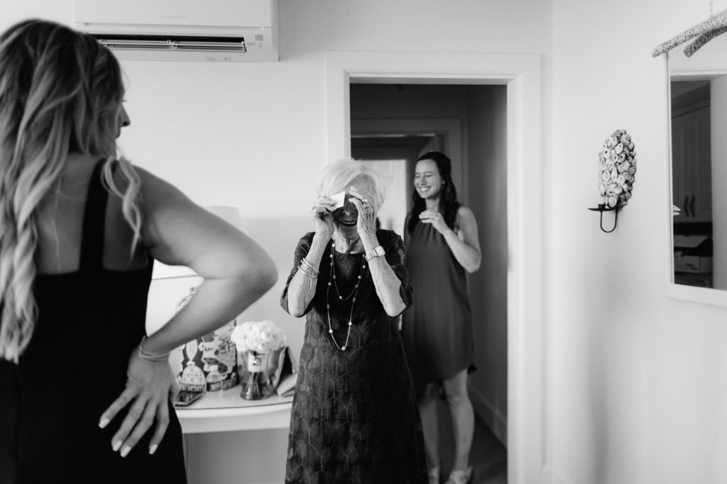 a grandma taking a photo of her granddaughter getting ready to get married on her wedding day