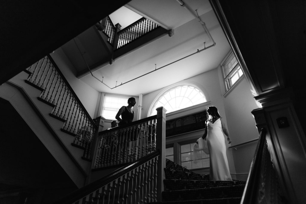amazing, textured, black and white shot of a bride coming down the stairs at the wianno club with the staircase winding above her