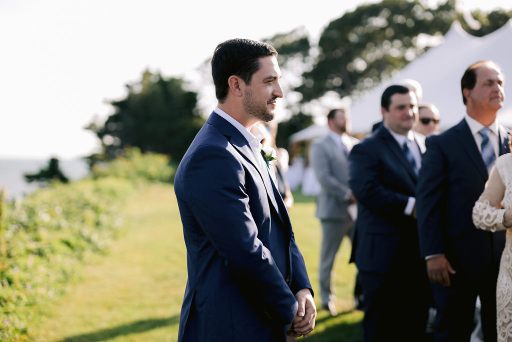 groom watches his bride walk down the aisle in this outdoor oceanside cape cod ceremony photographed by Jenny Fu Studio
