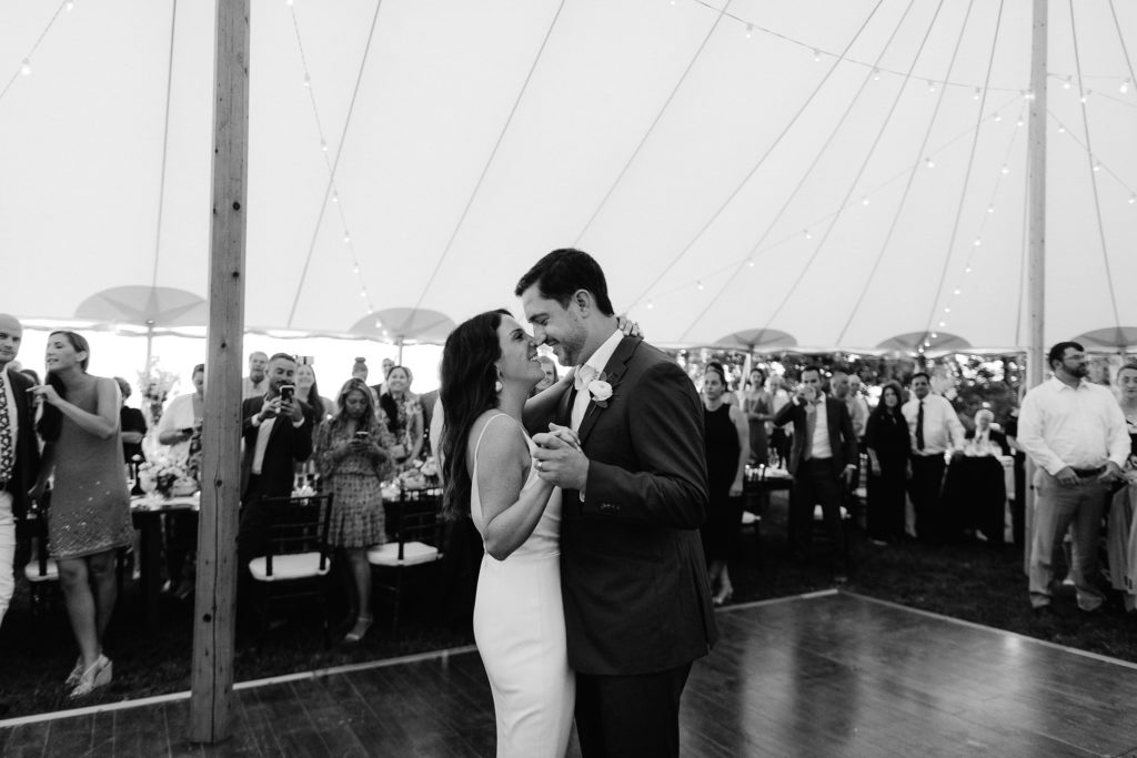 cape cod bride and groom enjoy their first dance under a beautiful tent at their oceanside cape cod wedding