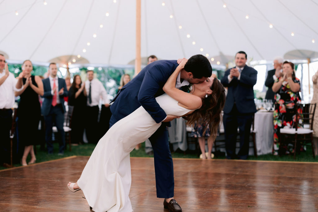 groom dips his bride at the end of their first dance as husband and wife at this gorgeous oceanside cape cod wedding