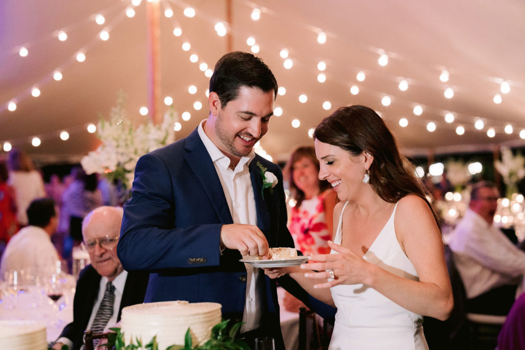 bride who looks like Kate Middleton cuts cake with her new husband at their cape cod wedding reception