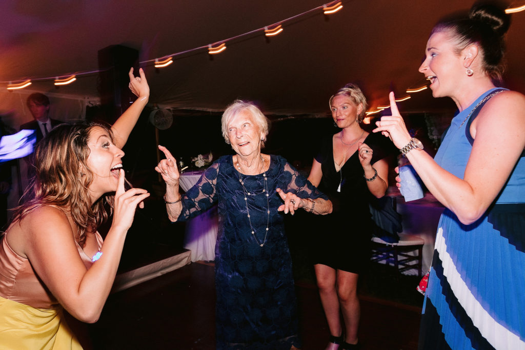 guests dance and enjoy themselves at a tent reception on the shores of cape cod in New York