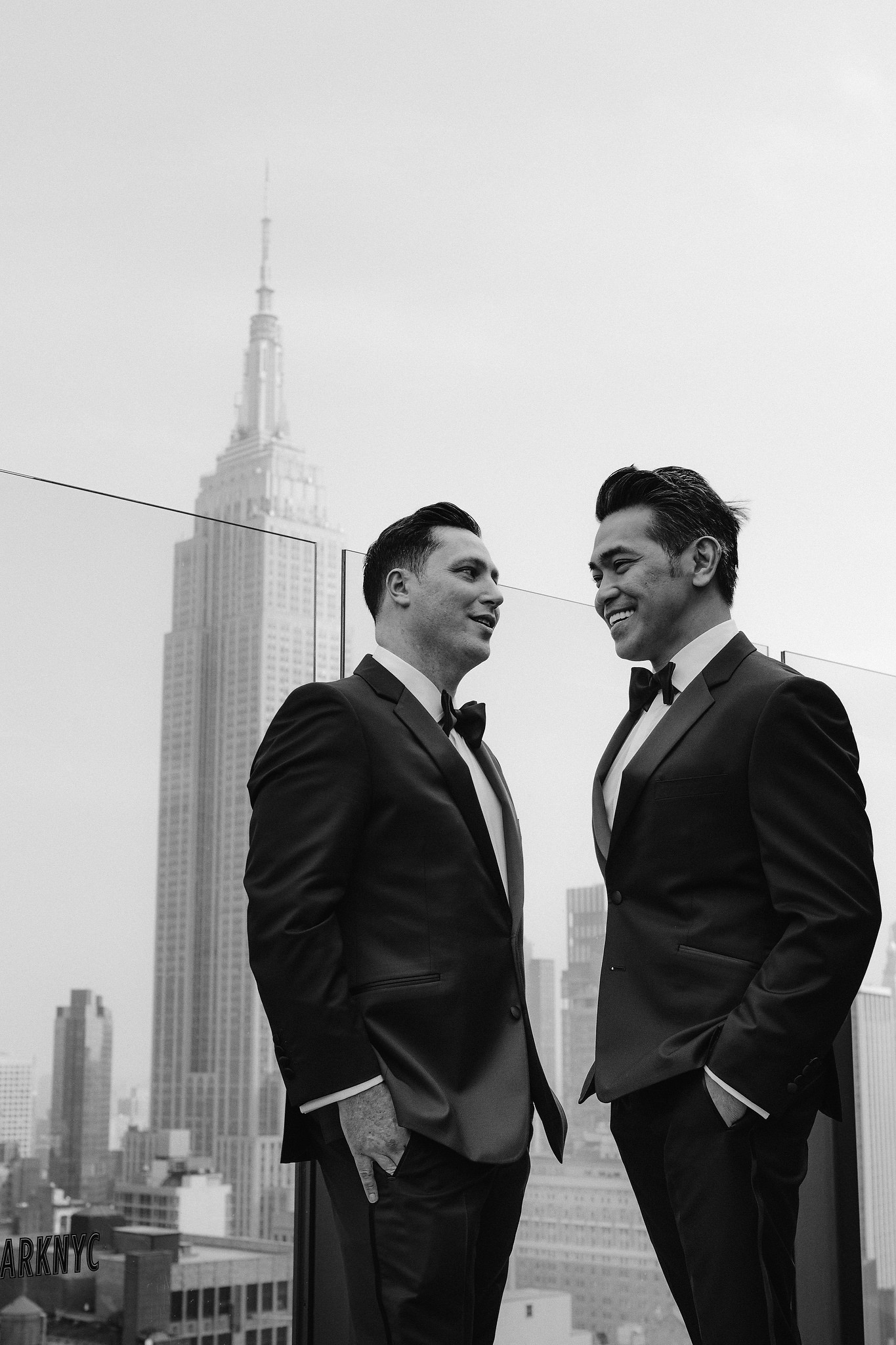 Groom and groom laughing on a rooftop patio in New York City