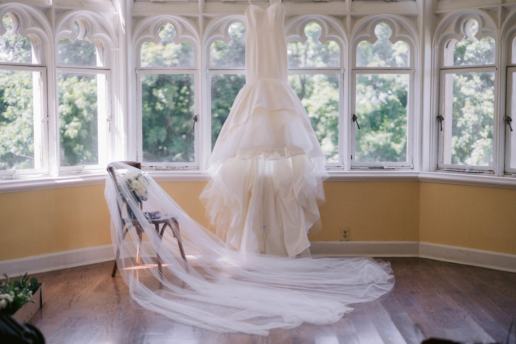 wedding dress hanging in the window at Castle Gould at Sands Point Preserve Conservancy