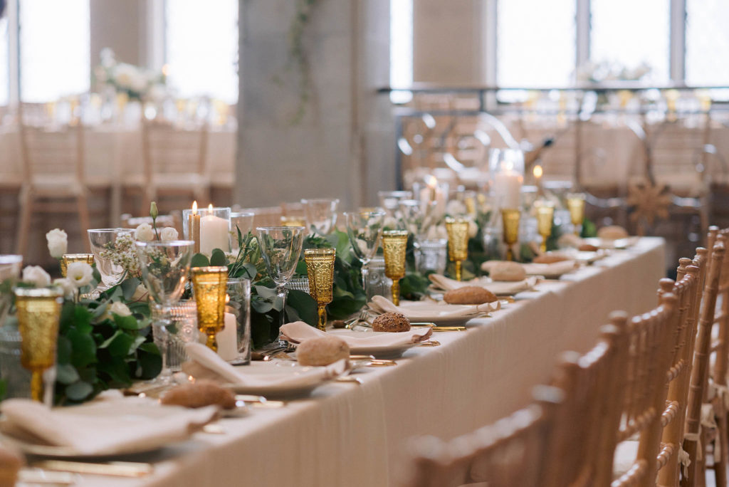 Reception decor at Castle Gould in New York showcases an opulent set up with greenery and gold