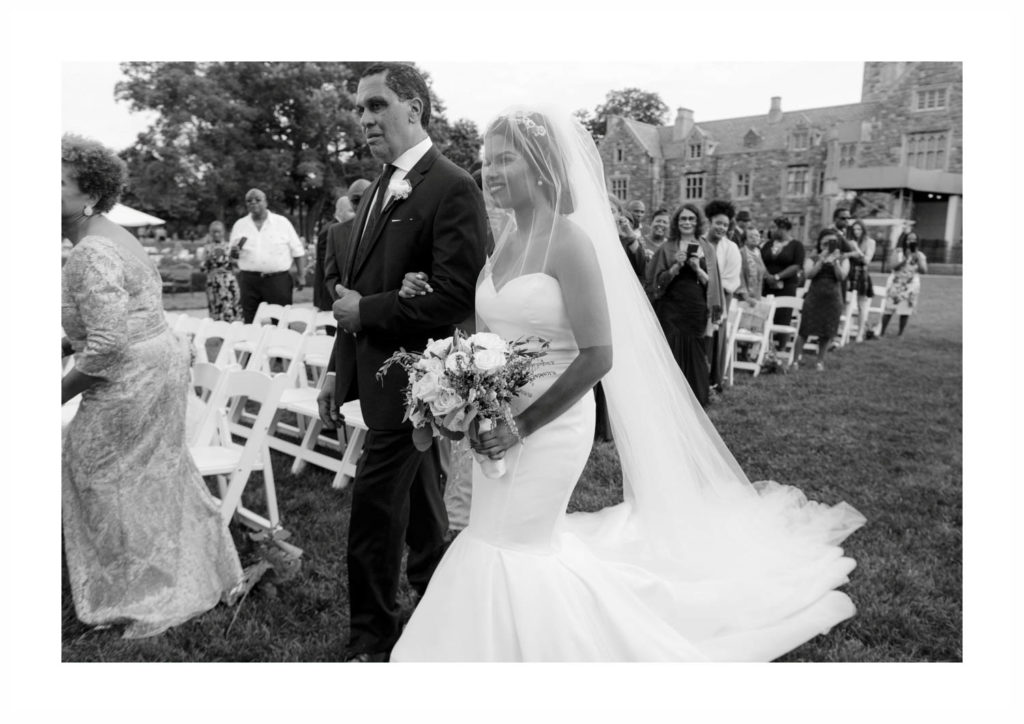 Happy bride walks down the aisle with her father in this outdoor ceremony at Castle Gould at the Sands point Preserve n NY