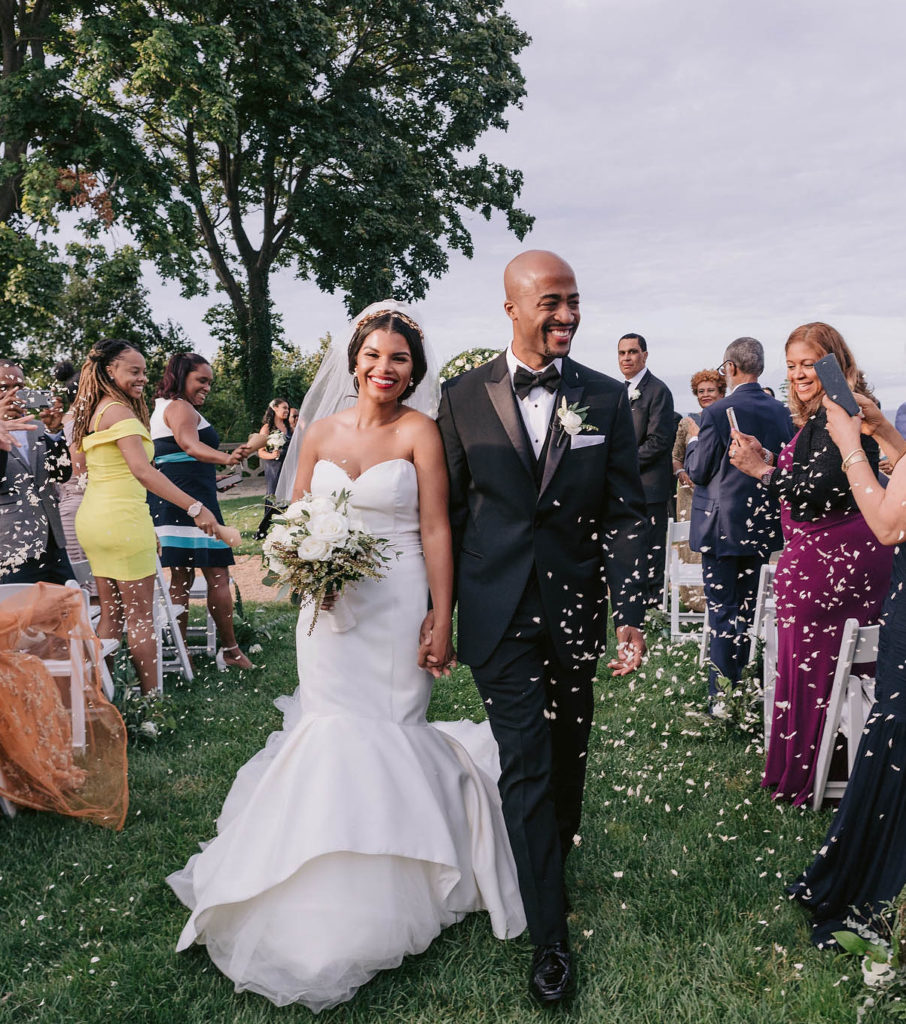 Newlywed couple walks down the aisle to confetti and smiles at this New York wedding on the grounds of the Sands Point Preserve