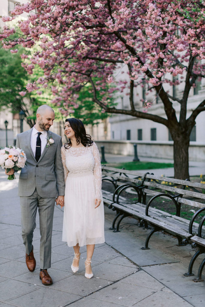 A new husband and wife walk the New York City Hall gardens after their elopement ceremony inside