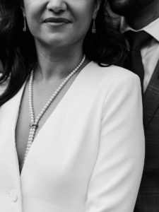close up of a bride wearing a wide pantsuit and a gorgeous string of pearls at new york city hall