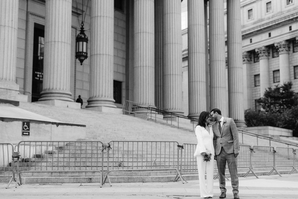 Newly married couple pose in front of the steps of New York City Hall after eloping there
