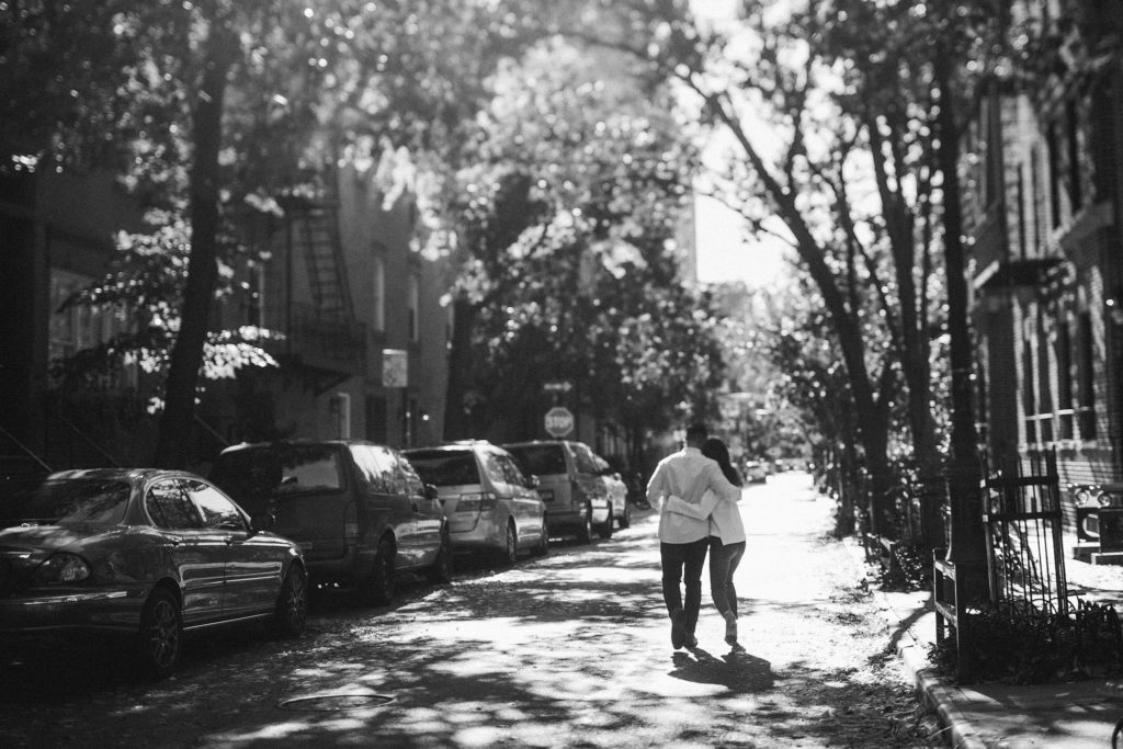 newly engaged asian couple walks through the west village on new york city during a beautiful, sunny fall day in this black and white image