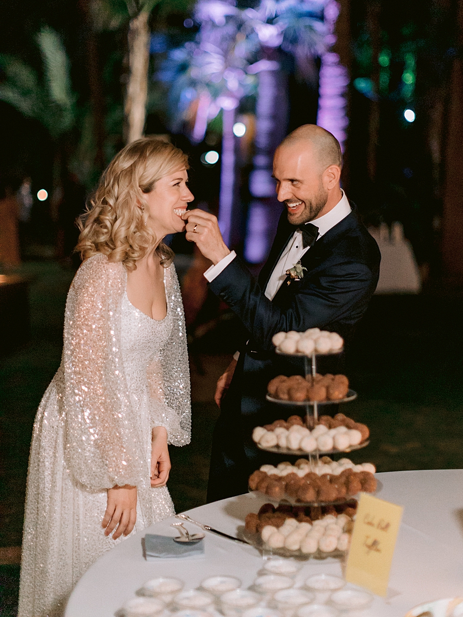 groom feeds bride a donut on wedding day