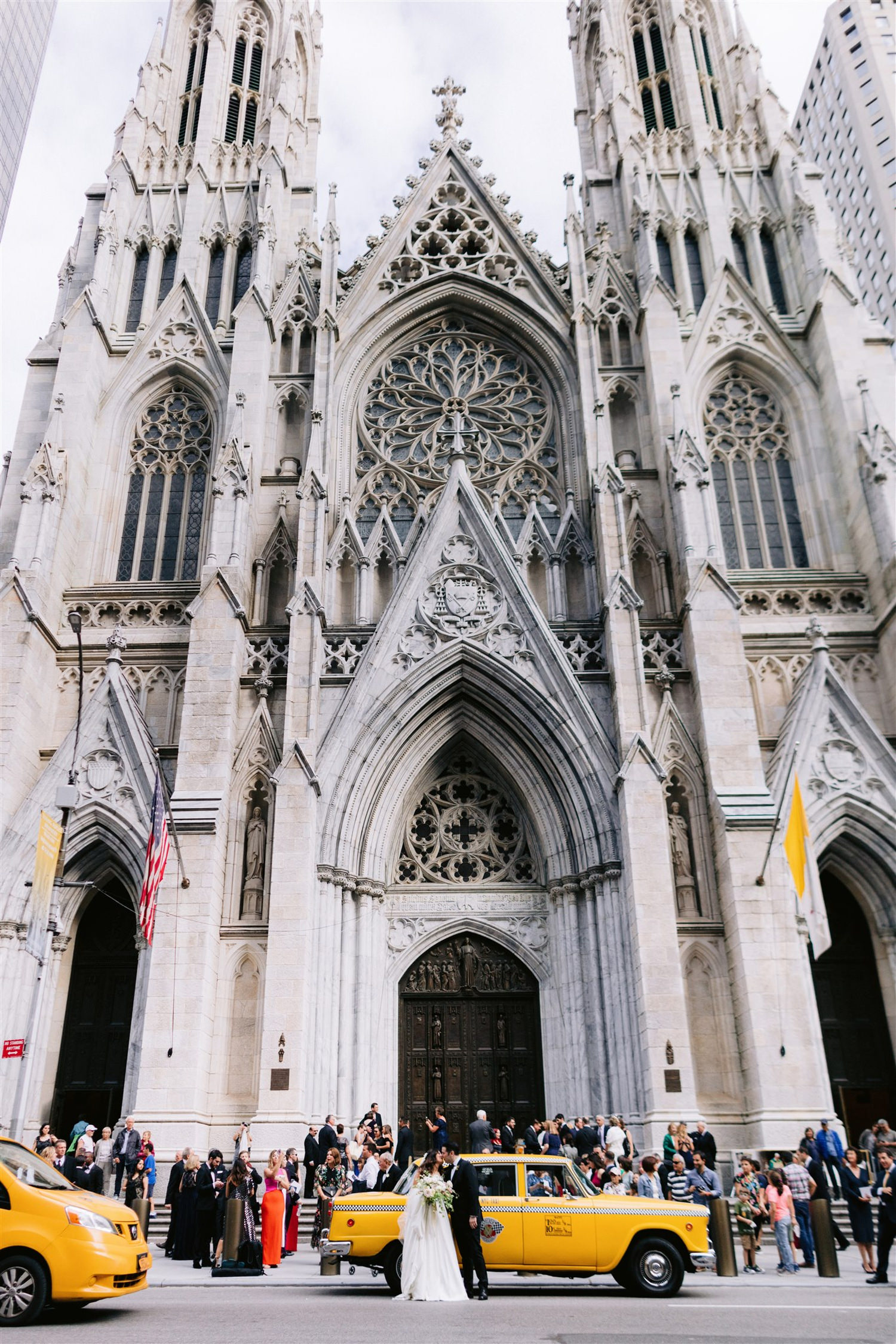 st. patricks cathedral, jw marriott essex house, bridal, wedding, classic new york wedding,  bride and groom share a kiss in front of a huge church in Manhattan nyc on 5th ave, fifth avenue, film cars New York, checker cab, Manhattan wedding