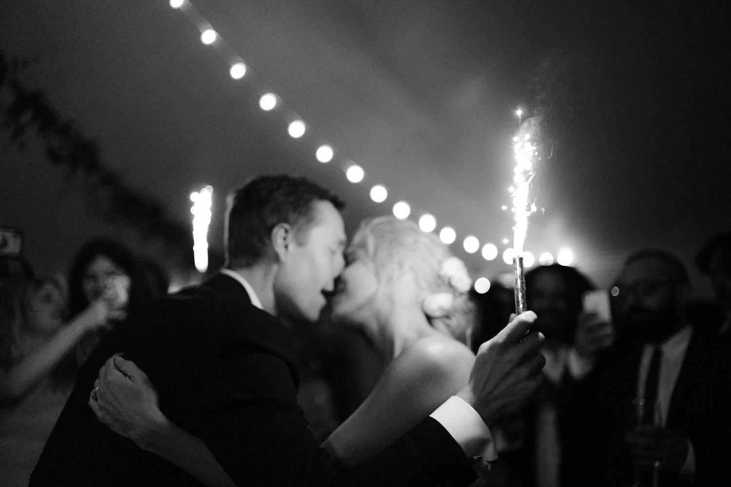 bride and groom kiss to the light of sparklers on the dance floor at Firefox Mountain House in New York