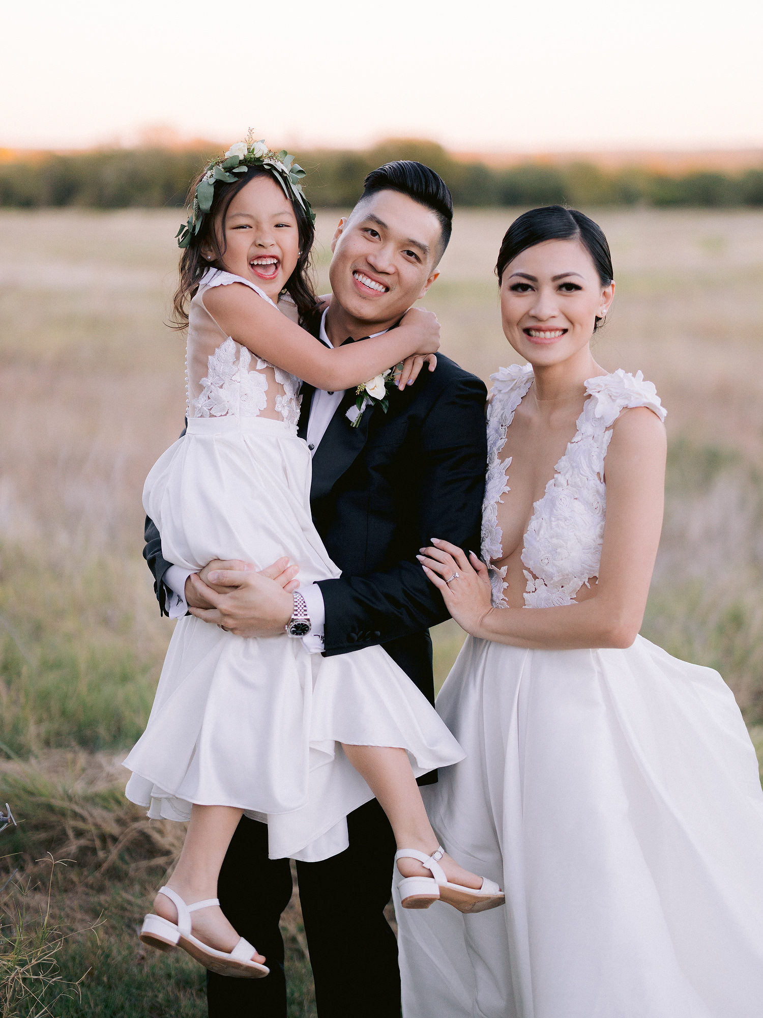 Bride, groom, and daughter on wedding day