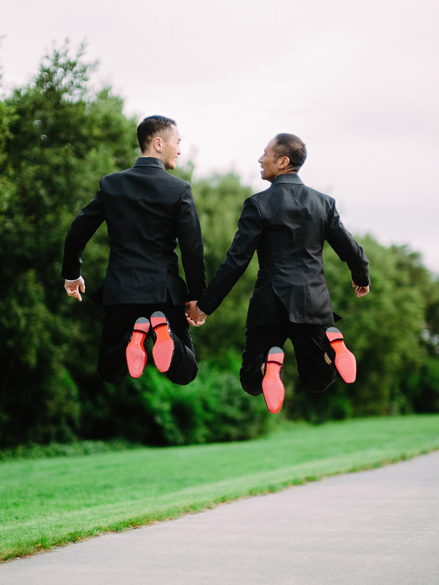 Husband and husband jumping on their wedding day