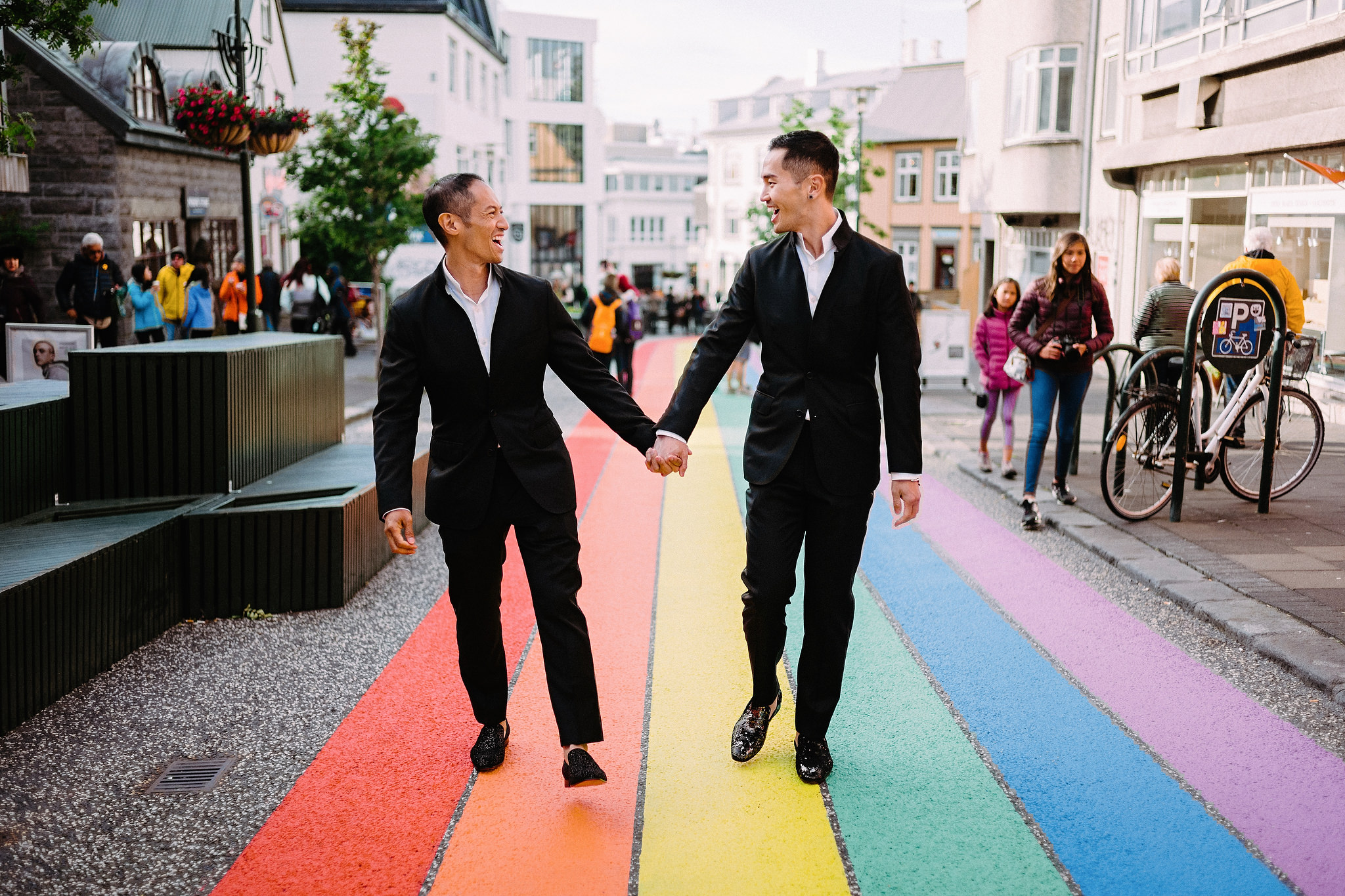 Couple walking down rainbow crosswalk 