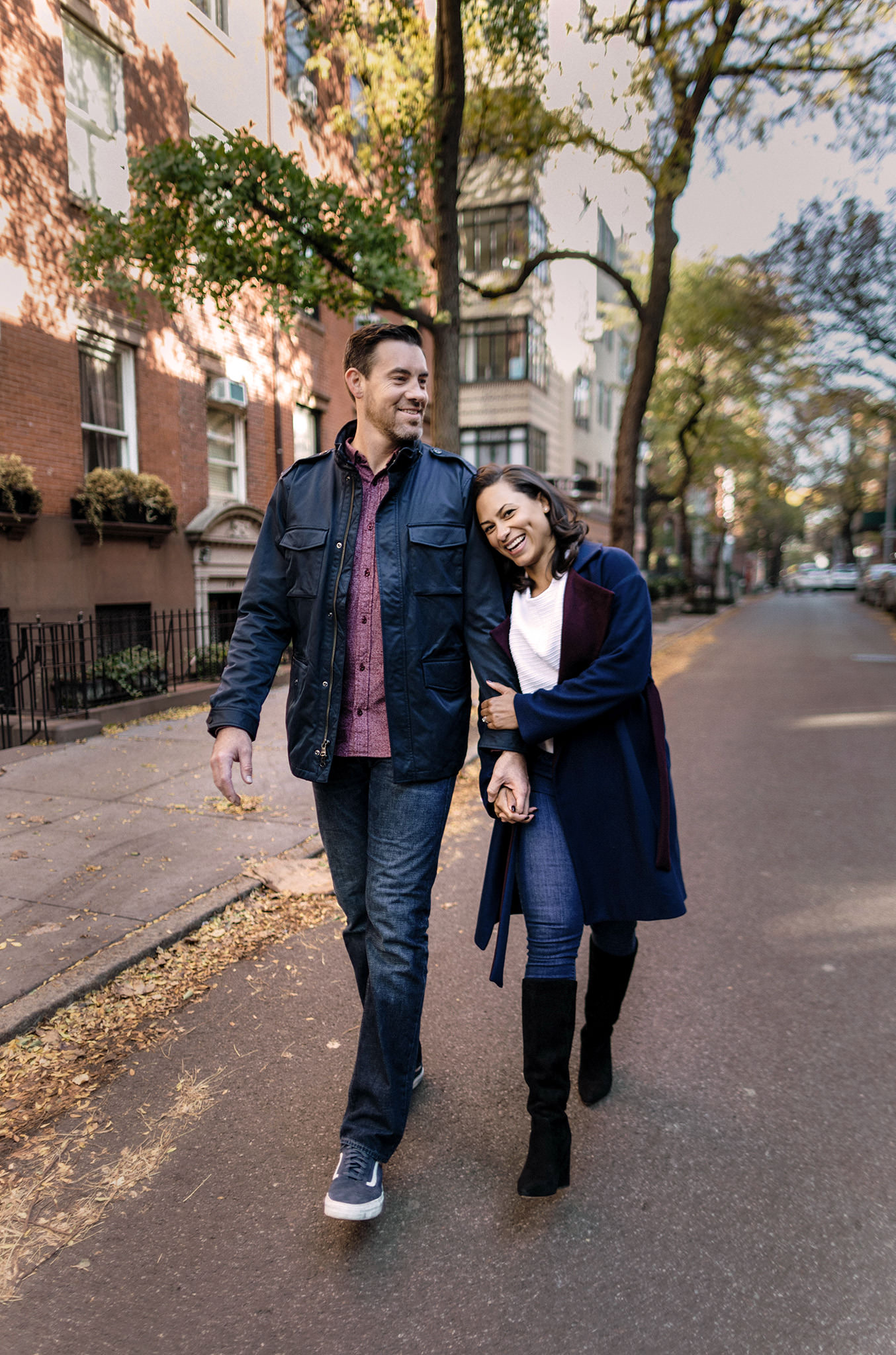 Couple holding hands and smiling as they walk through Brooklyn Heights