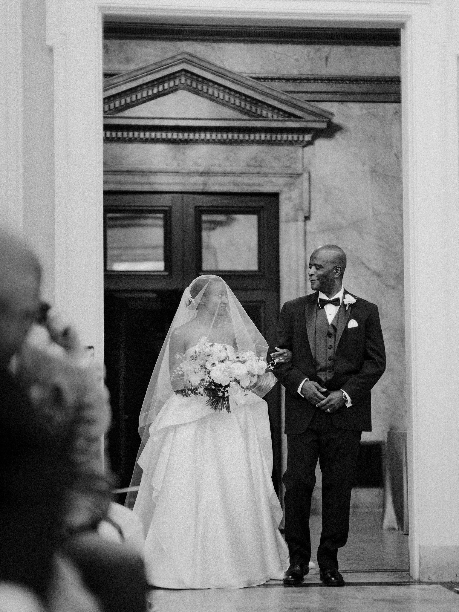 Bride in wedding dress holding bouquet getting walked down the aisle by her father, Providence Public Library