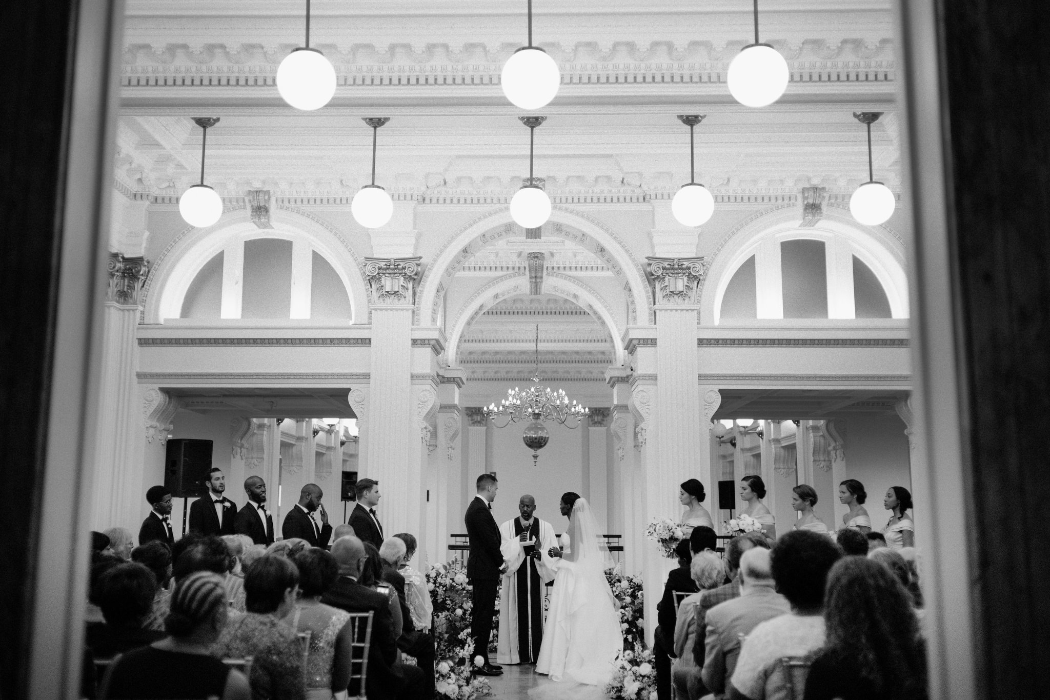 View down the aisle of an interracial couple on their wedding day at Providence Public Library