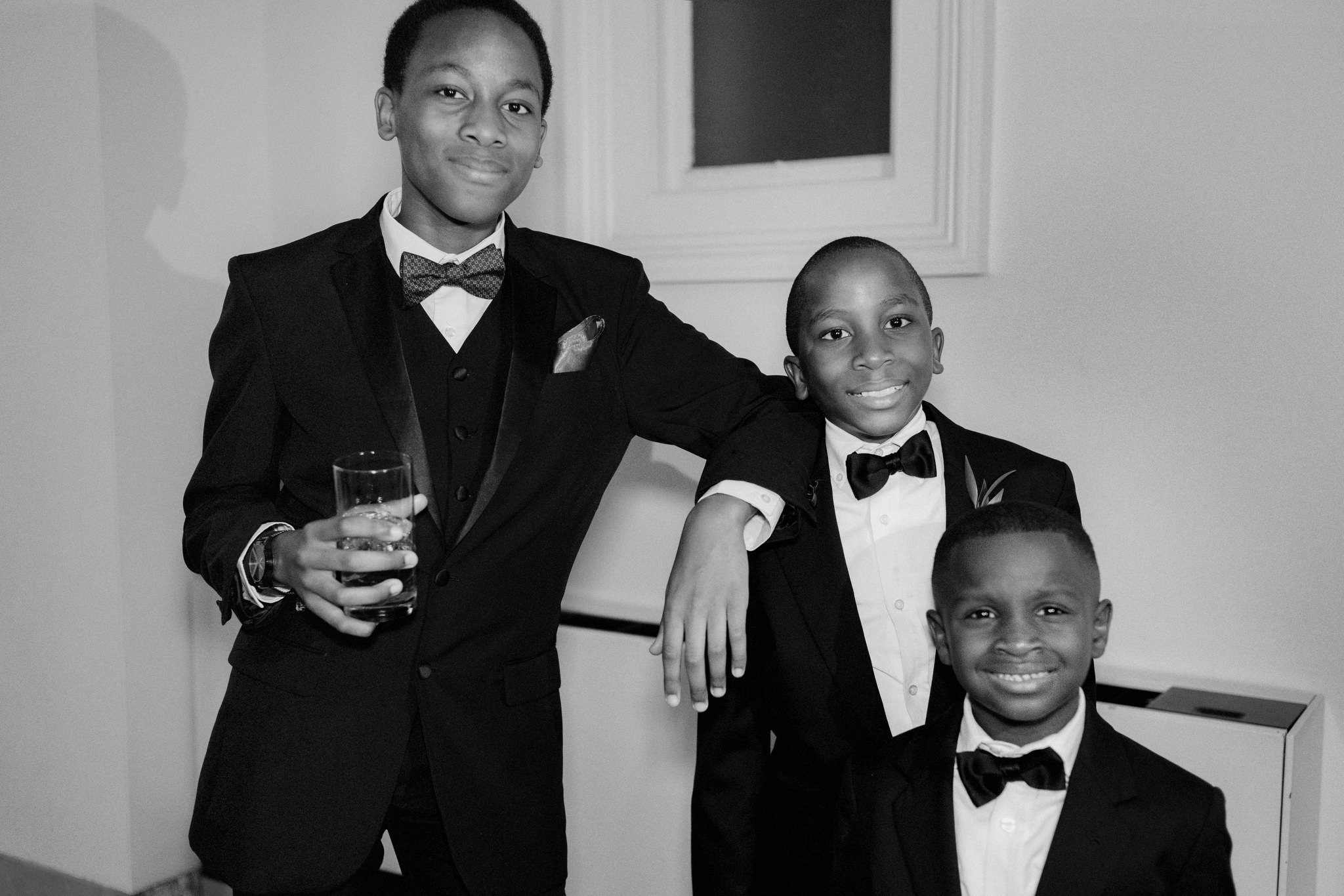 Three young boys smiling while wearing suits during a wedding at the Providence Public Library in Rhode Island