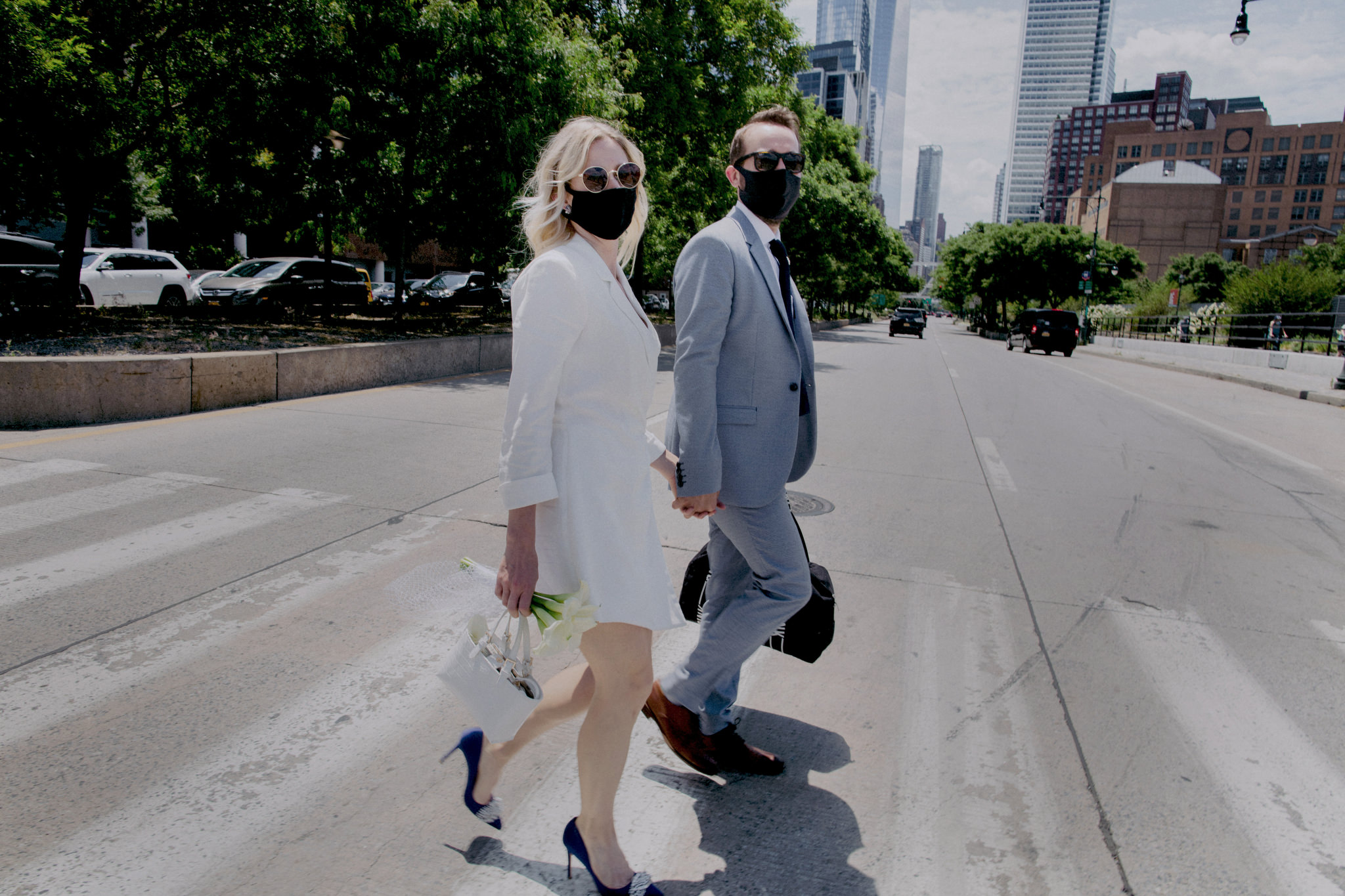 Newly married couple crossing the west side of Manhattan with black face masks on because of covid-19