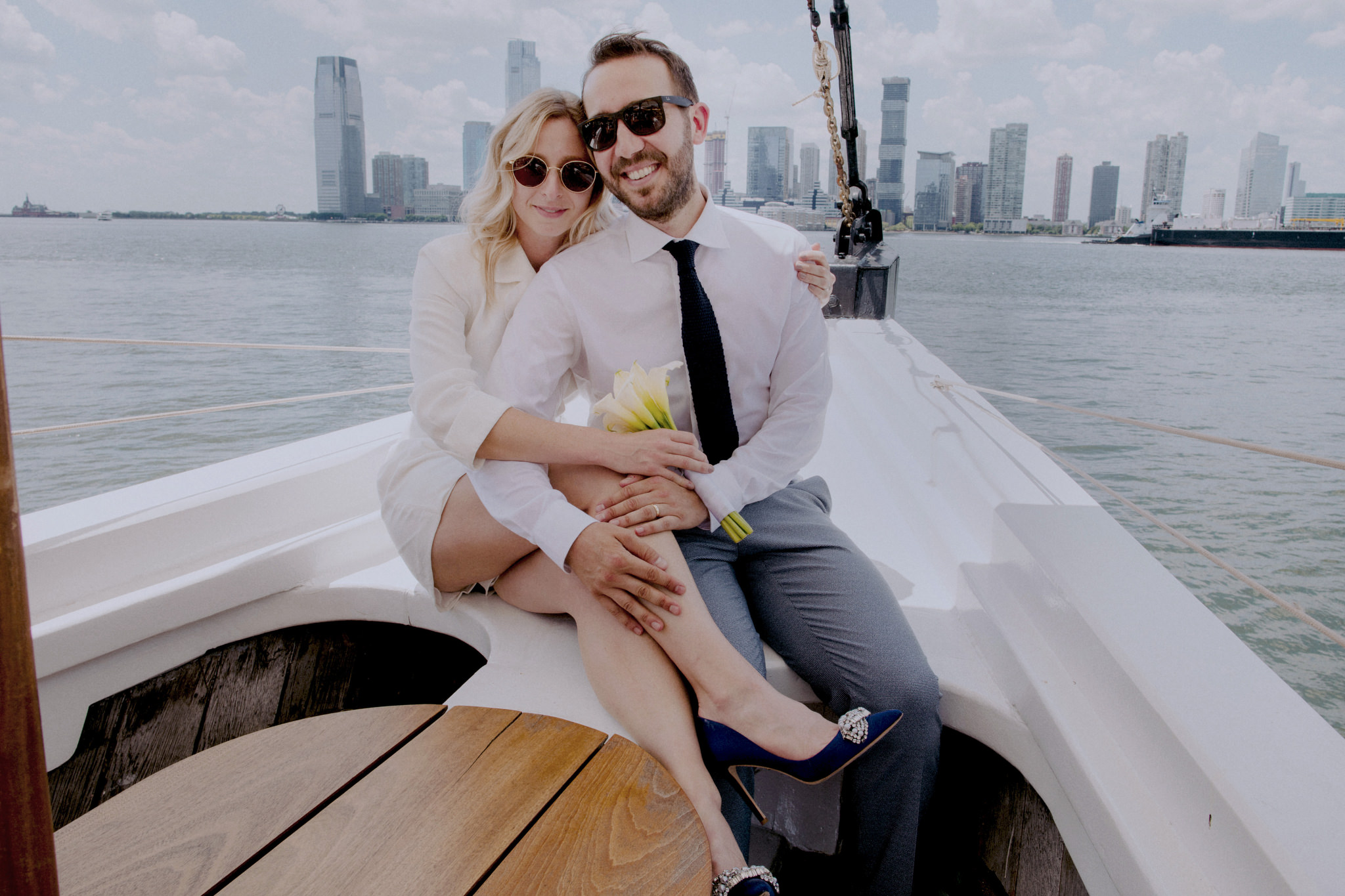 Bride and groom sitting together on boat in Manhattan during micro wedding
