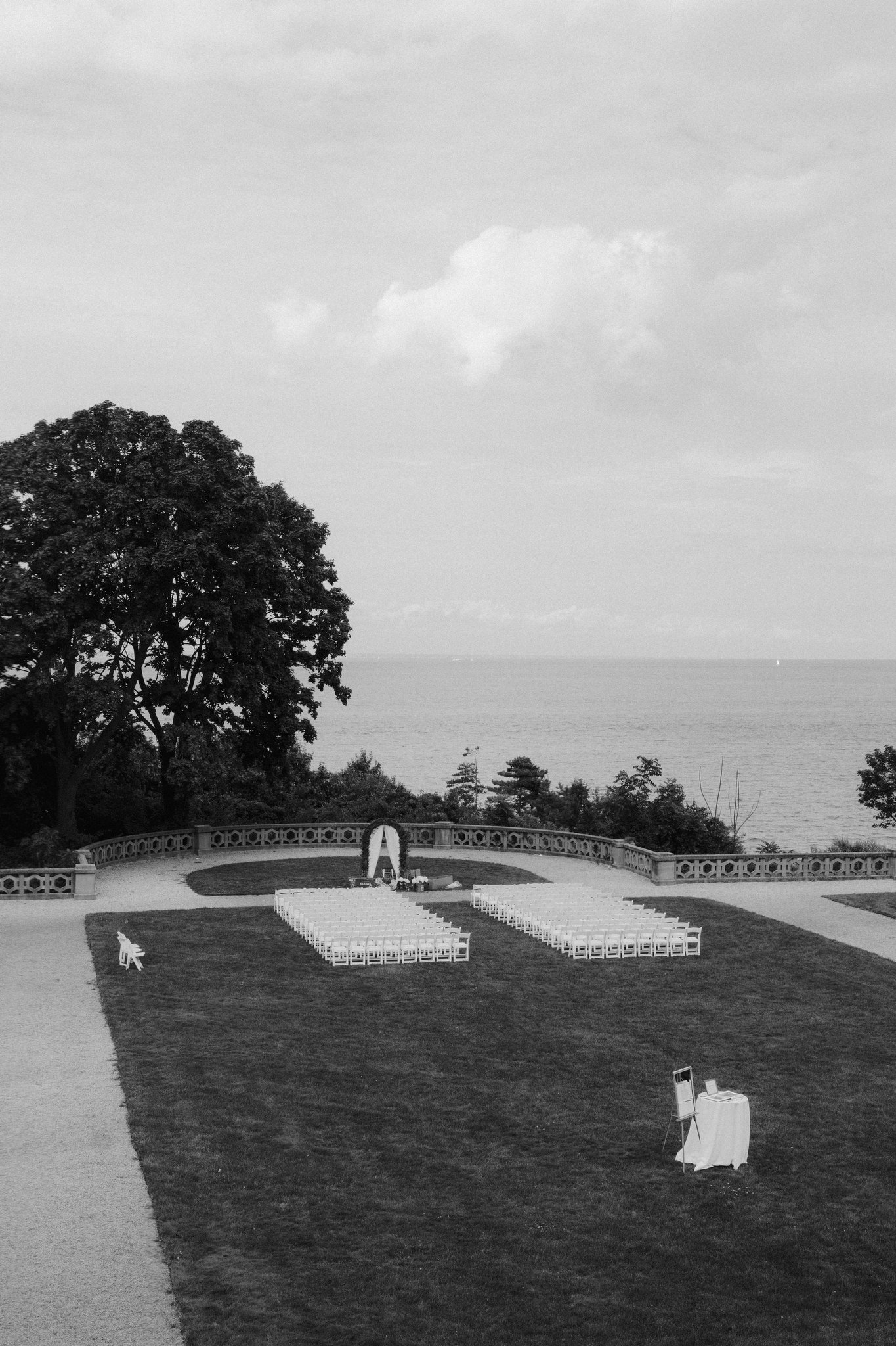 View of wedding ceremony set up on lawn beside ocean