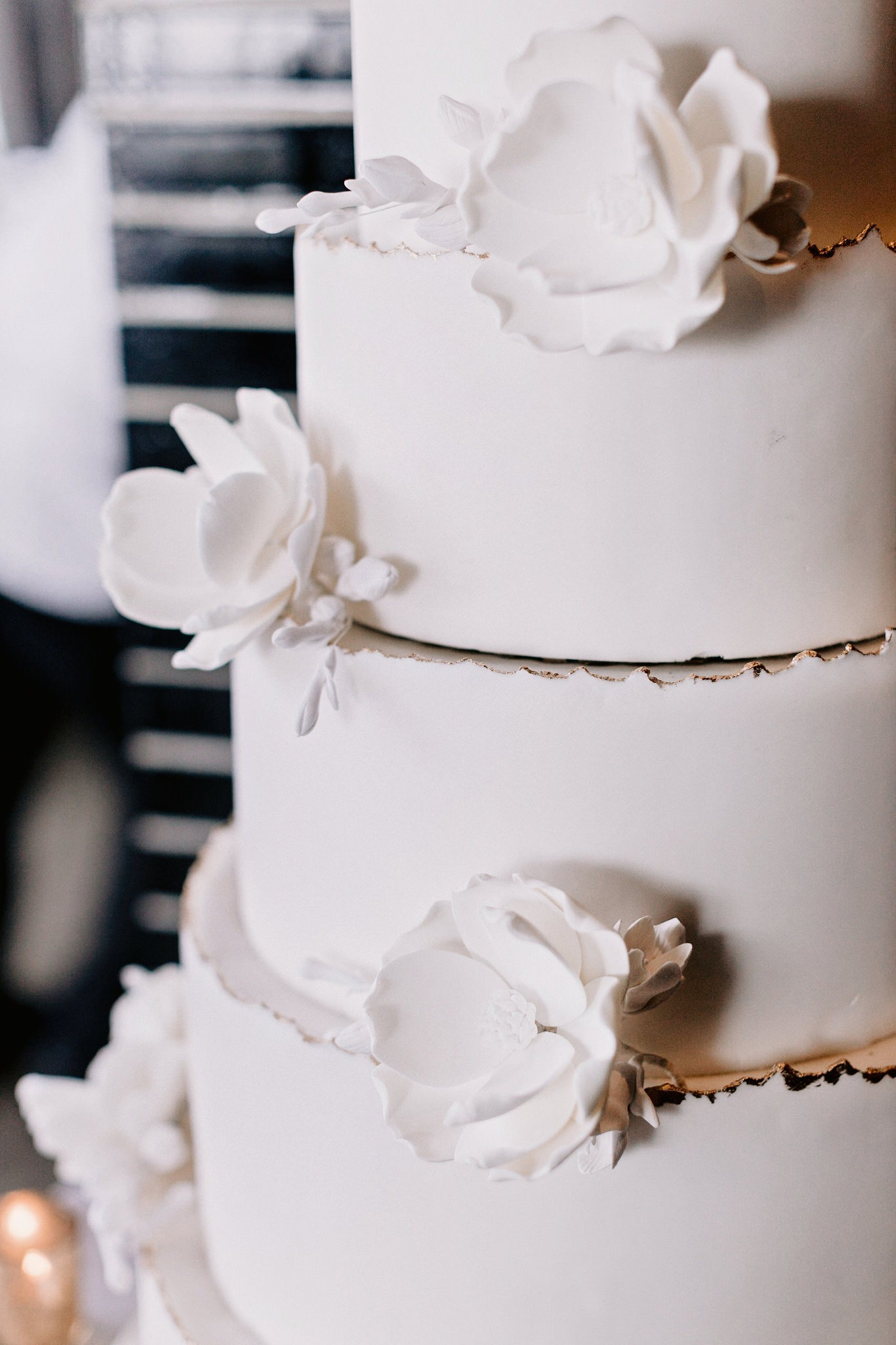 Close up of 5 tier white wedding cake with white flowers