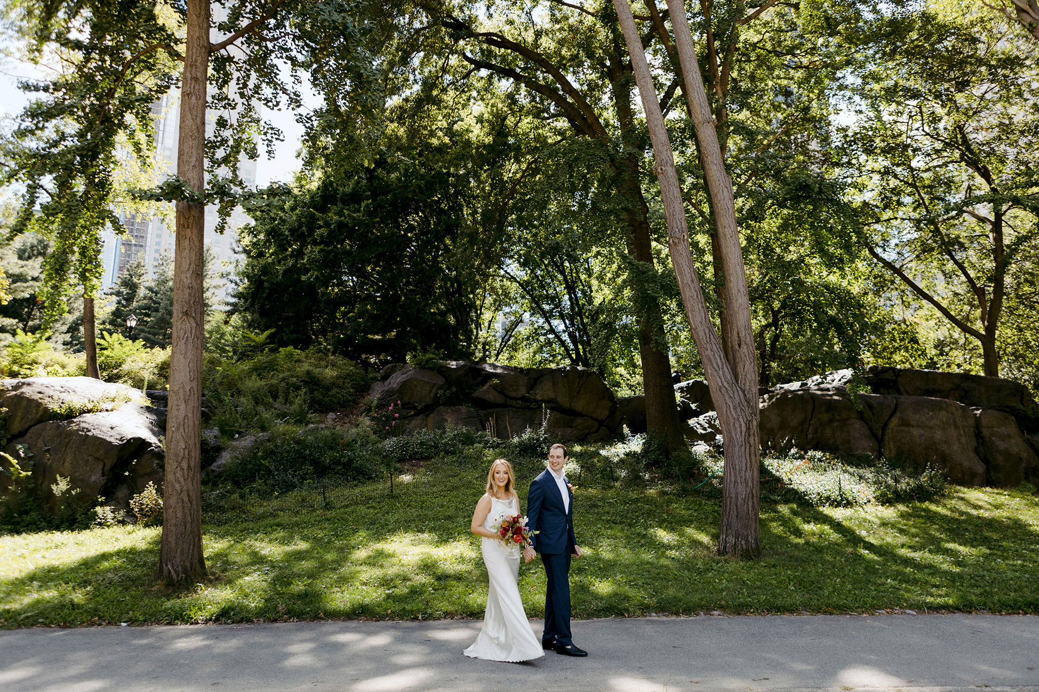 Man and wife walking through Central Park on their wedding day