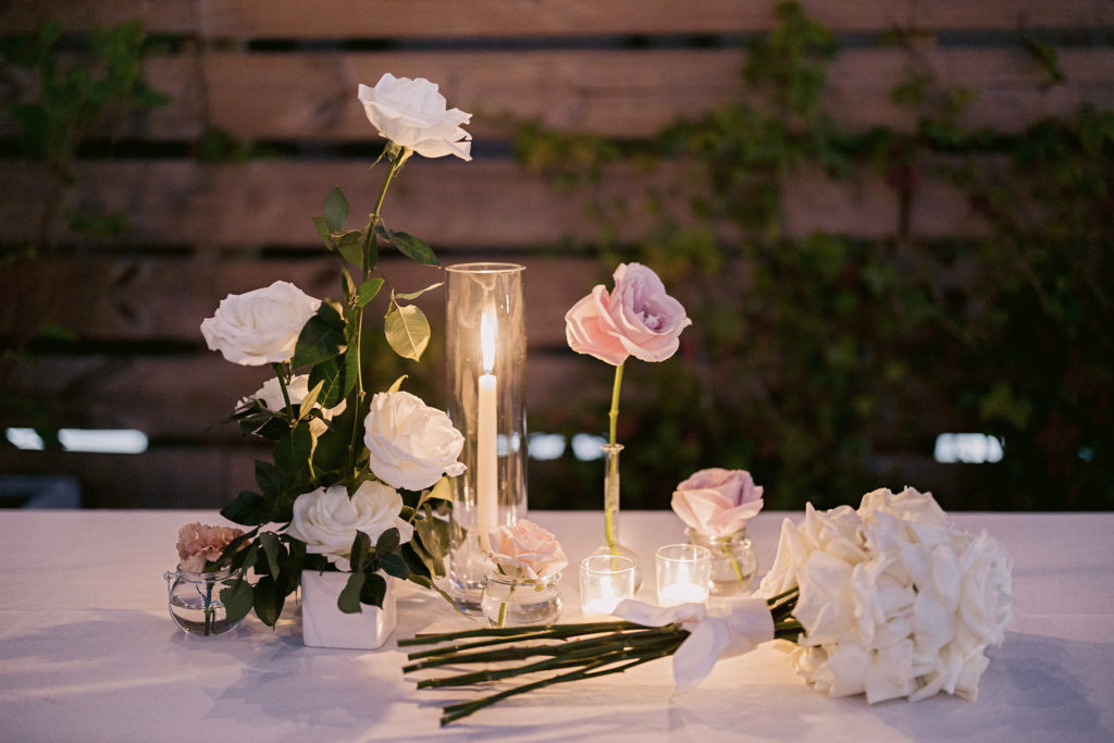 Pink roses and candles on a white table cloth