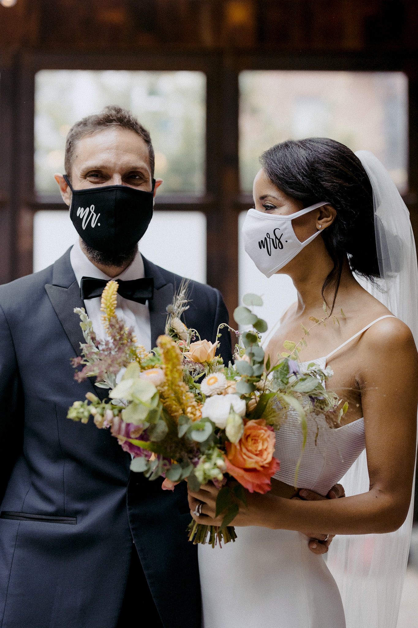 Bride and groom with Mr and Mrs masks on in Brooklyn, New York