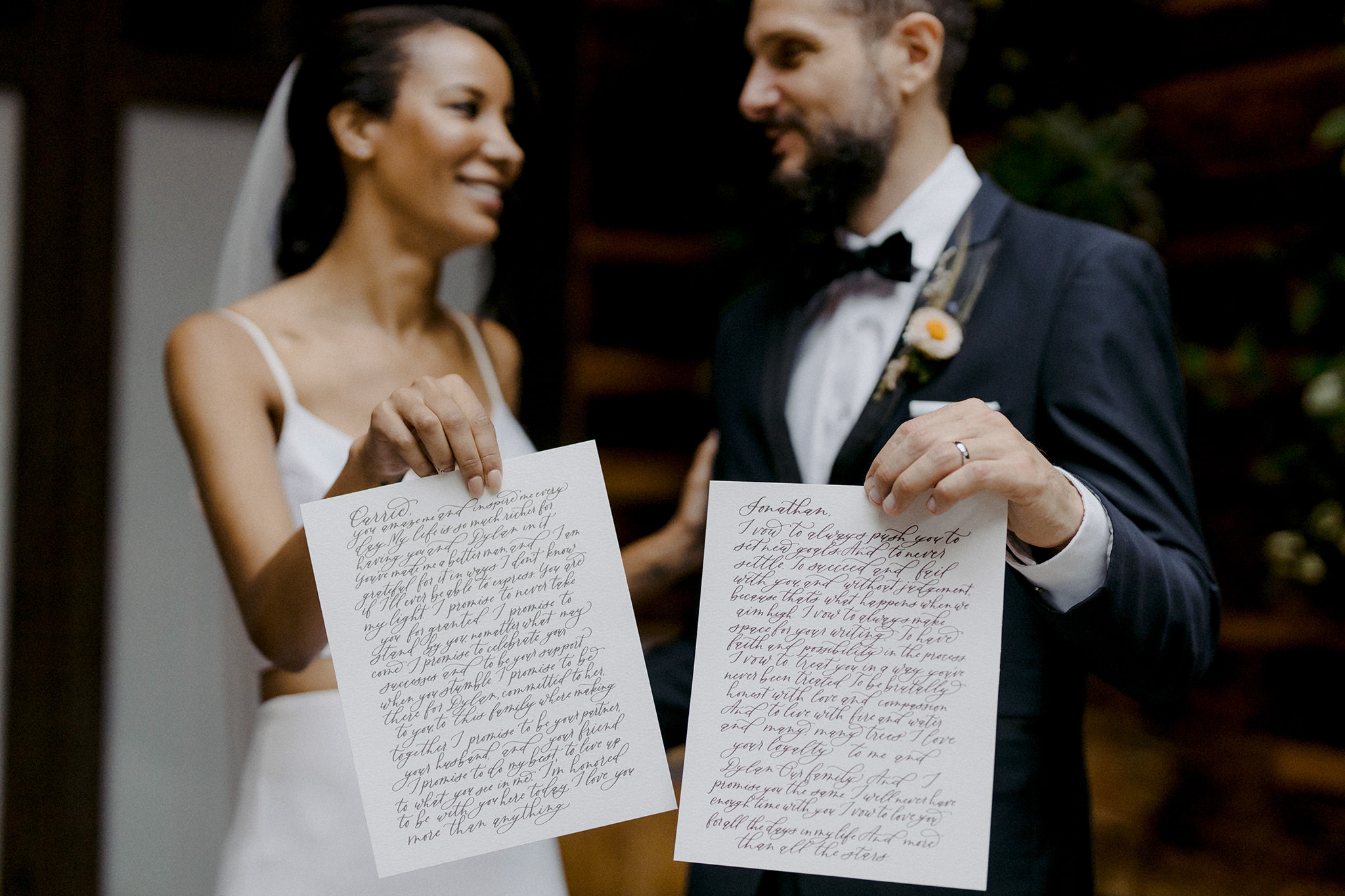 Bride and groom holding their custom calligraphy wedding vows