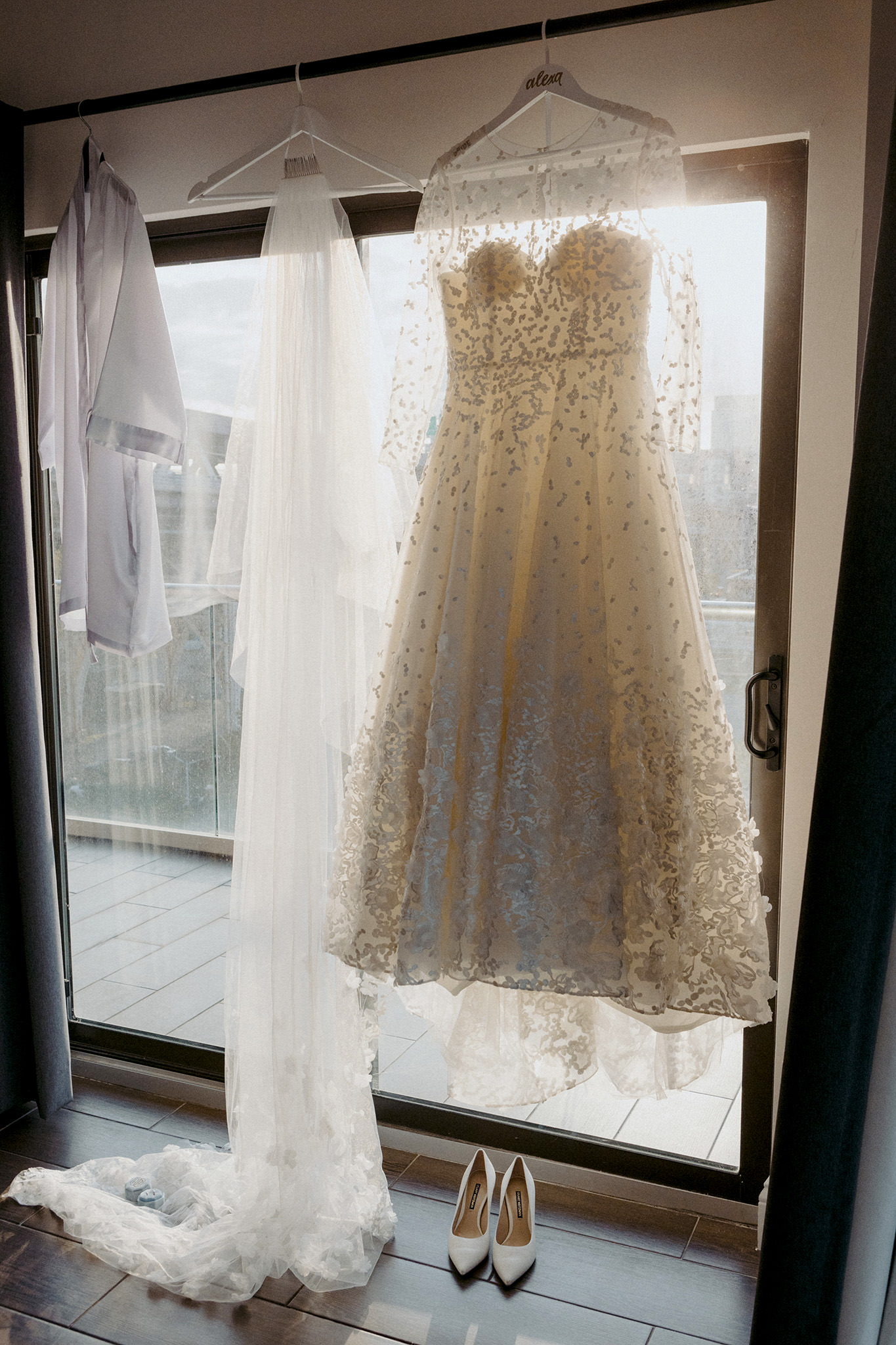Brides wedding dress hanging in the window at the Ravel Hotel