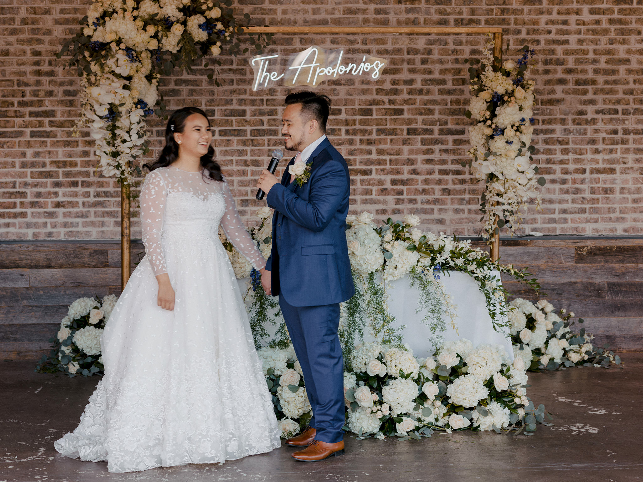 Bride and groom in front of a alter of white flowers