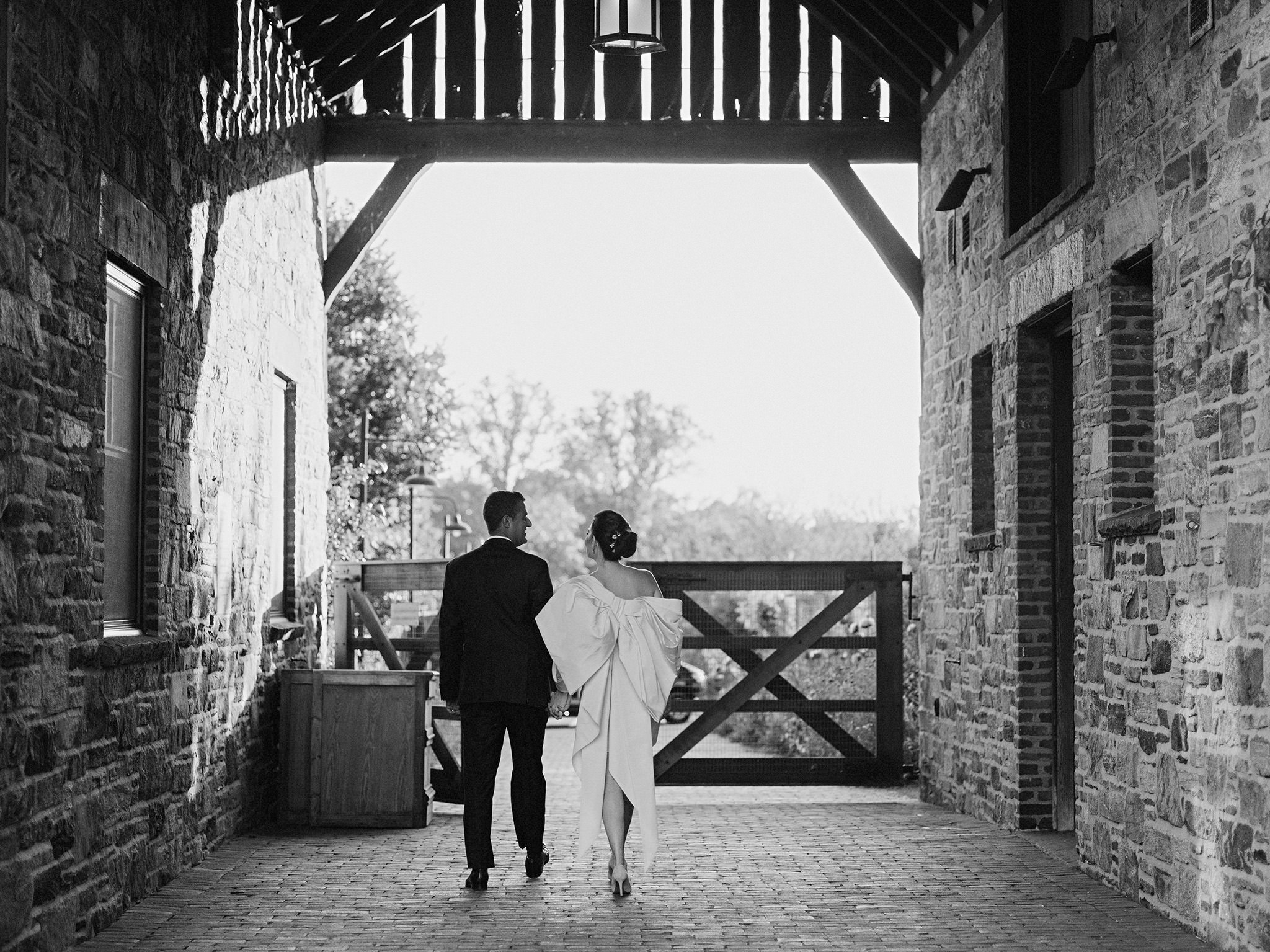 Couple walking through the stables at Blue Hill at Stone Barns