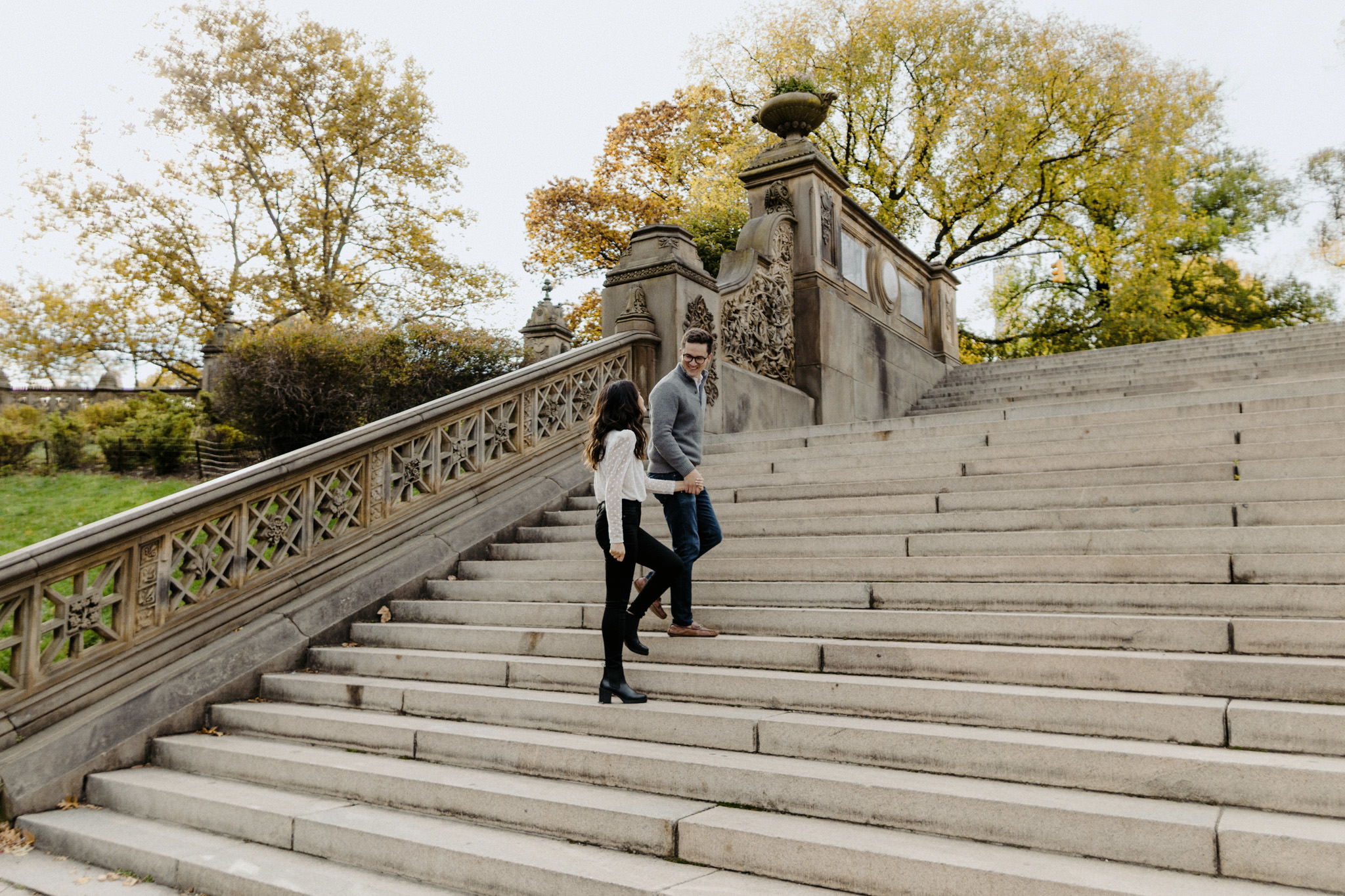 Engaged couple walking up steps in Central Park