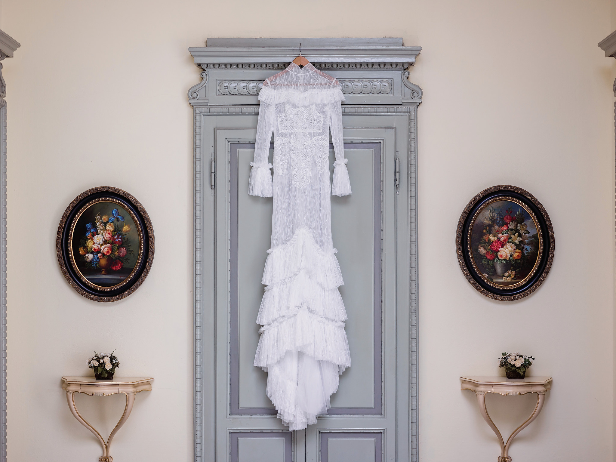 A lace wedding dress hangs from a wardrobe in Italy