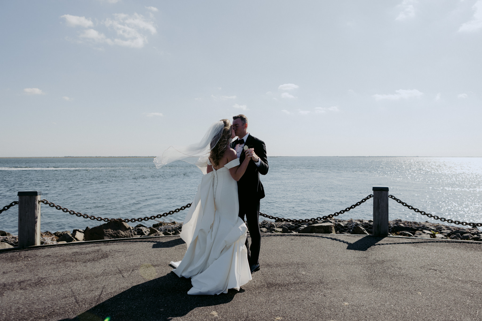 Bride and groom kiss at the Riviera Waterfront Mansion in Long Island