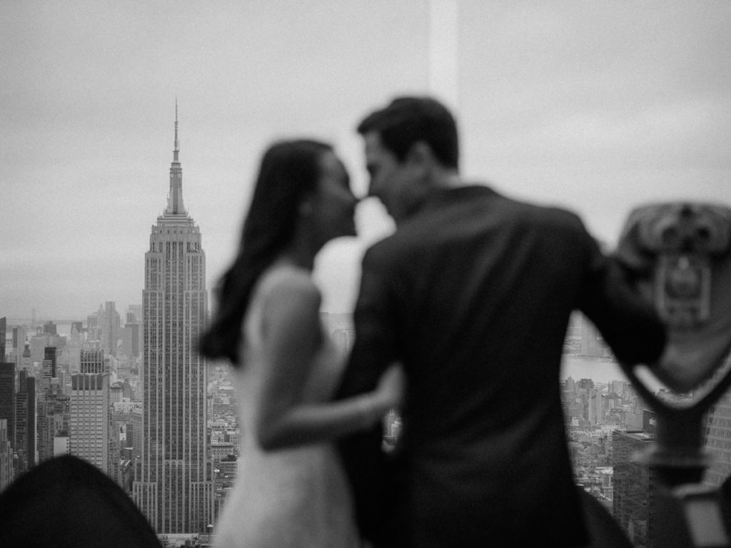 Man and woman kiss with the Empire State Building in the background