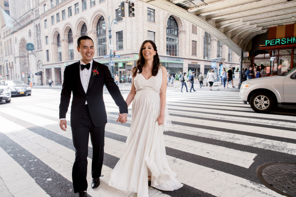 Bride and groom walk through a crosswalk outside of Grand Central Terminal