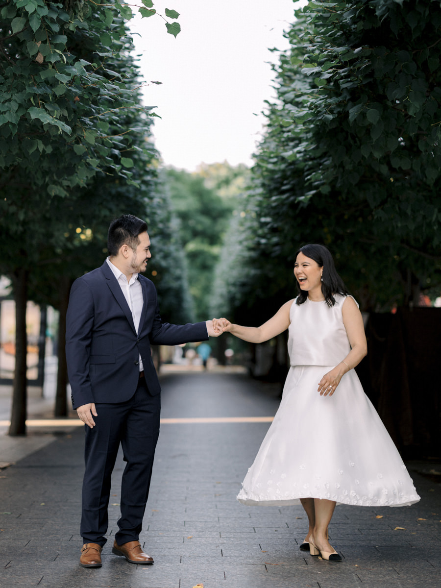 Groom spins his bride around in Central Park